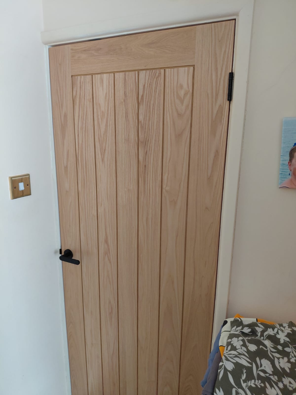 Full-length oak Suffolk-style door with black lever handle