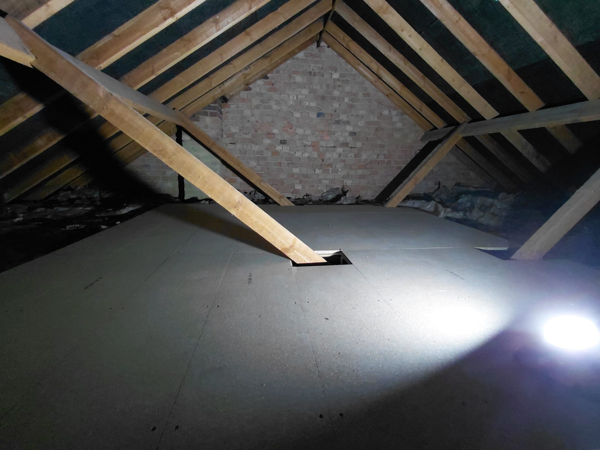 Newly boarded loft floor with exposed rafters