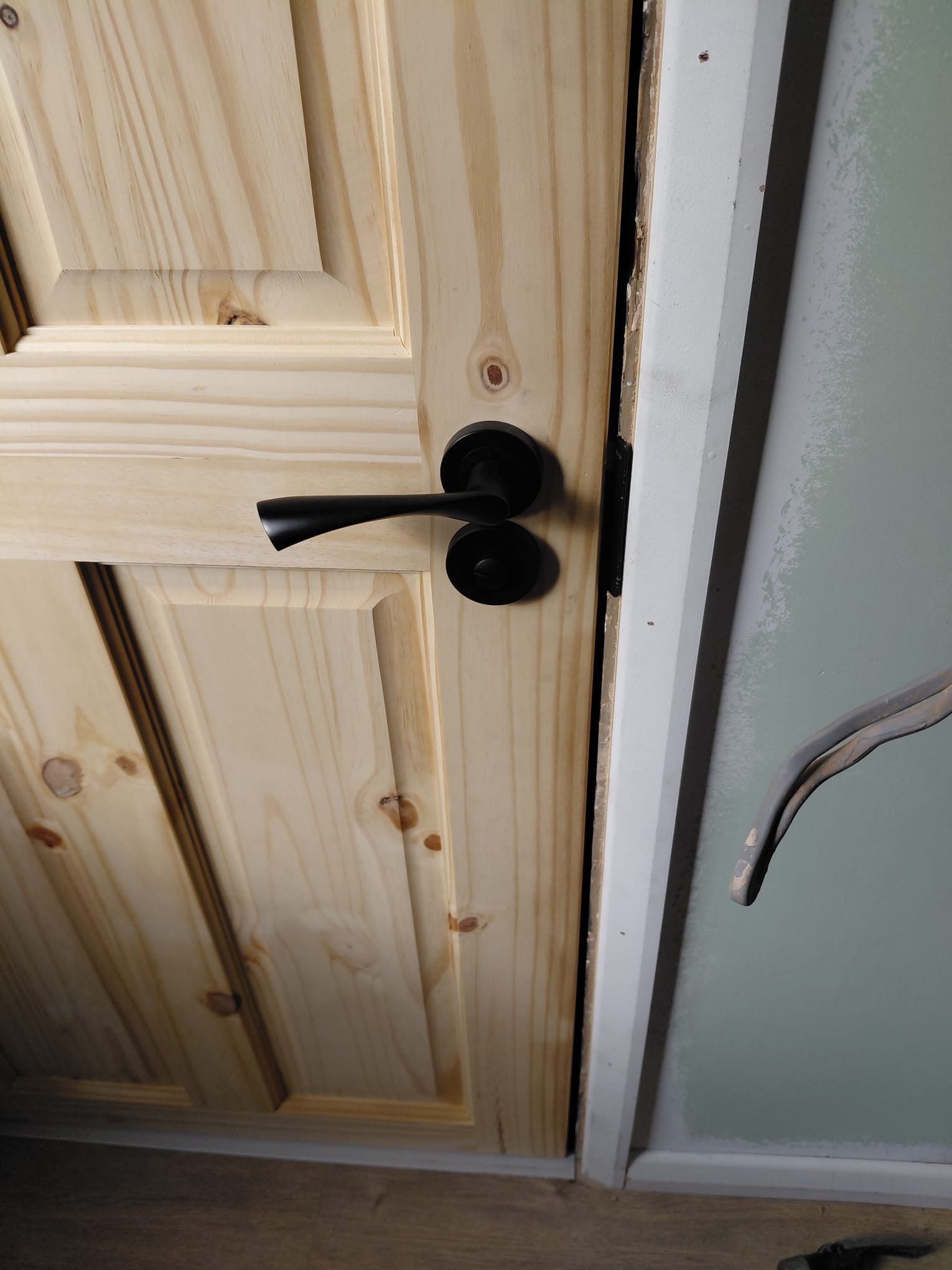 Knotty pine panel door with matte black handle